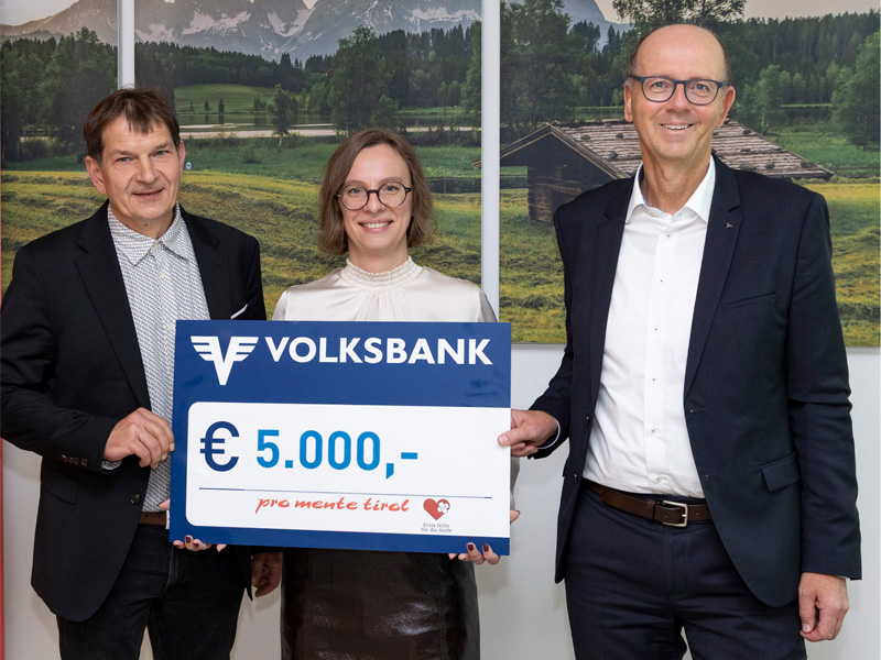 Spendenschek in Höhe von 5000 Euro wird von Volksbank Vorstand Martin Holzer an einen Mann und eine Frau von ProMente übergeben.