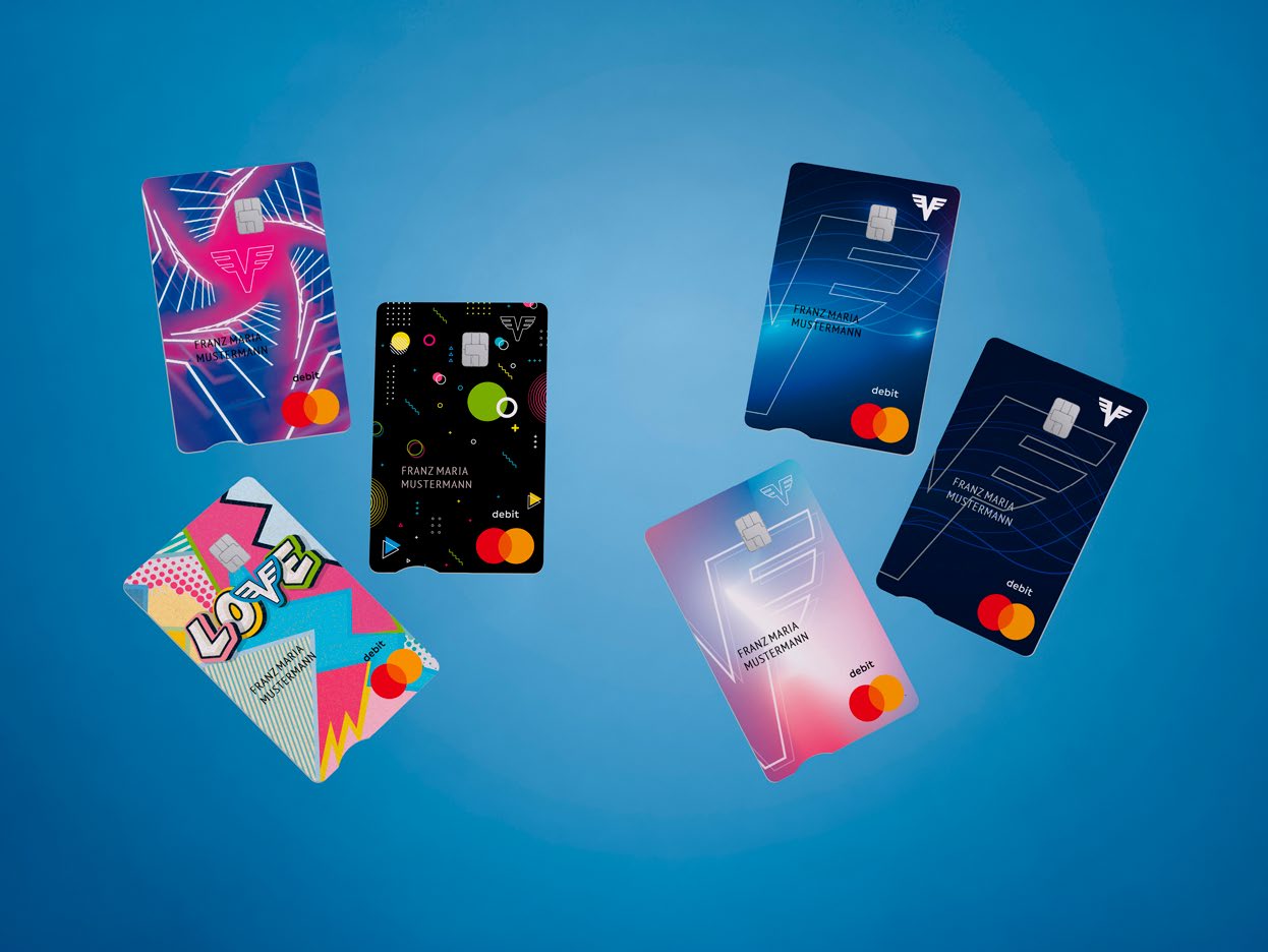 Eine Übersicht der neuen Kartendesigns der Volksbank vor einem blauen Verlaufshintergrund.